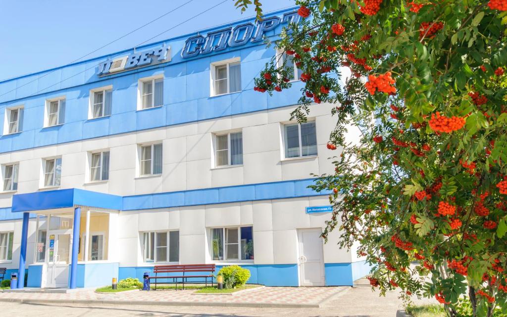 un edificio azul y blanco con un banco en la parte delantera en Lovech Sport, en Riazán