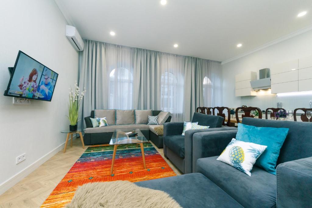 sala de estar con sofás azules y TV en V&V luxury apartments (Arena City,Maydan), en Kiev