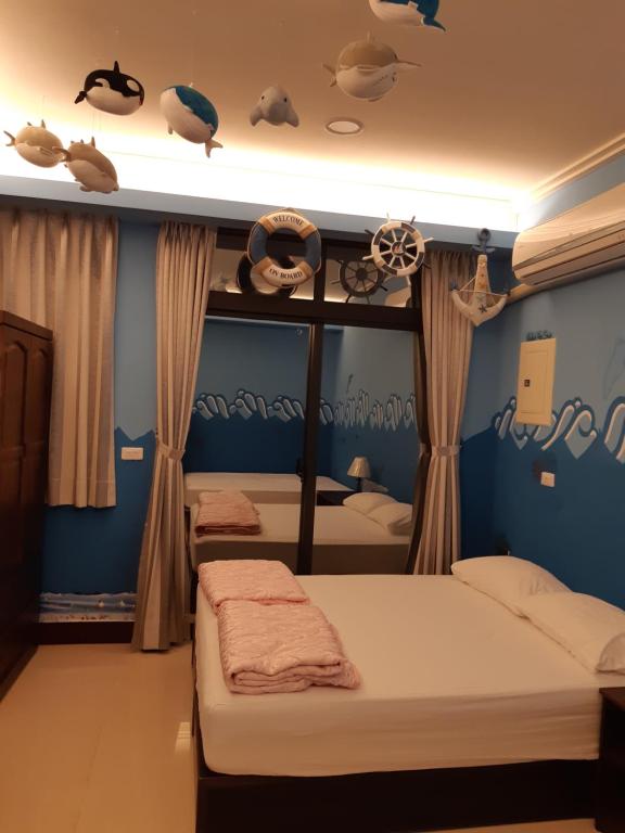 a bedroom with two beds and a blue wall at Passion in Magong