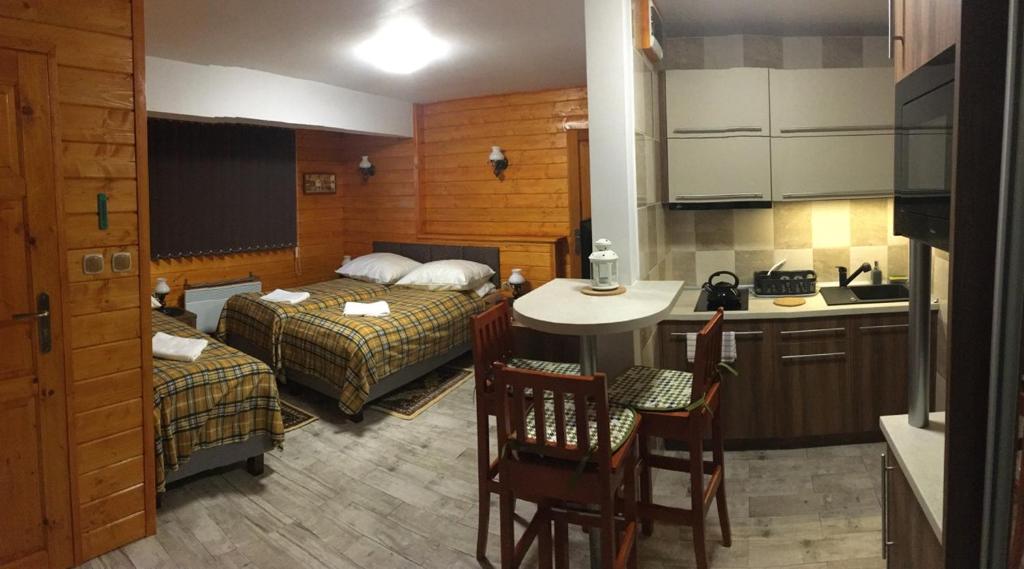 ein Schlafzimmer mit 2 Betten und eine Küche mit einem Tisch in der Unterkunft Stacja Narciarska SOSZÓW Wisła in Wisła