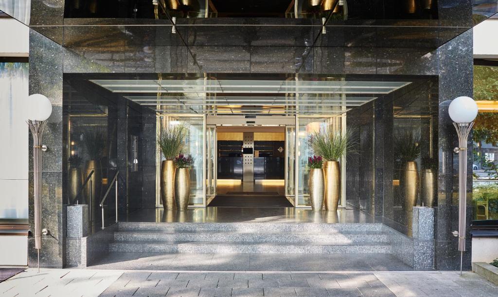 a lobby of a building with stairs and plants at Living Hotel Kanzler in Bonn