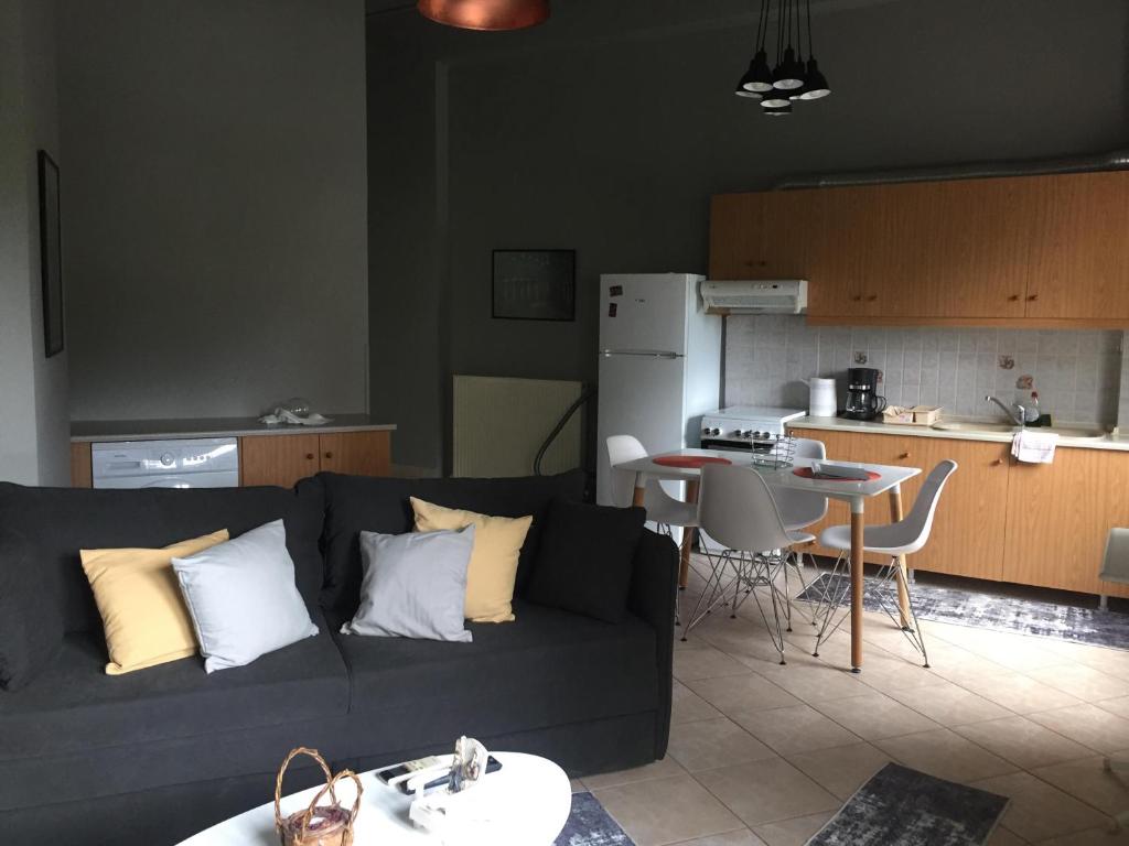 a living room with a black couch and a kitchen at Sofie's Choice Mytilini Ι in Mytilene