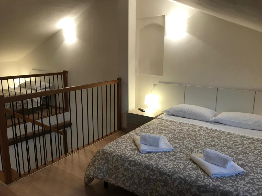 una camera da letto con un letto e due asciugamani di APPARTAMENTI del DUCA a Ferrara