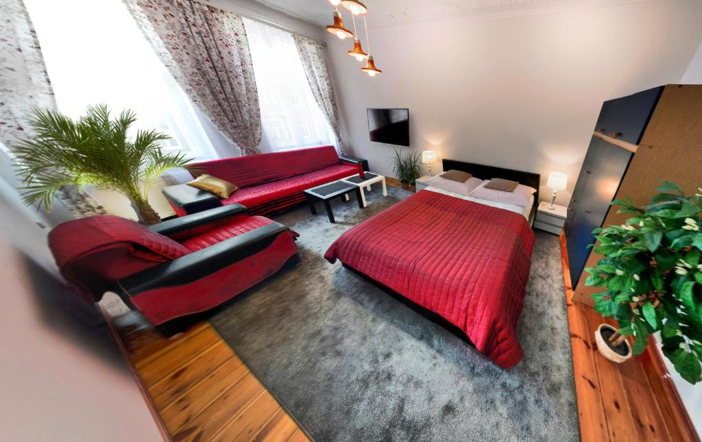 sala de estar con cama roja y sofá en Havana, en Wroclaw