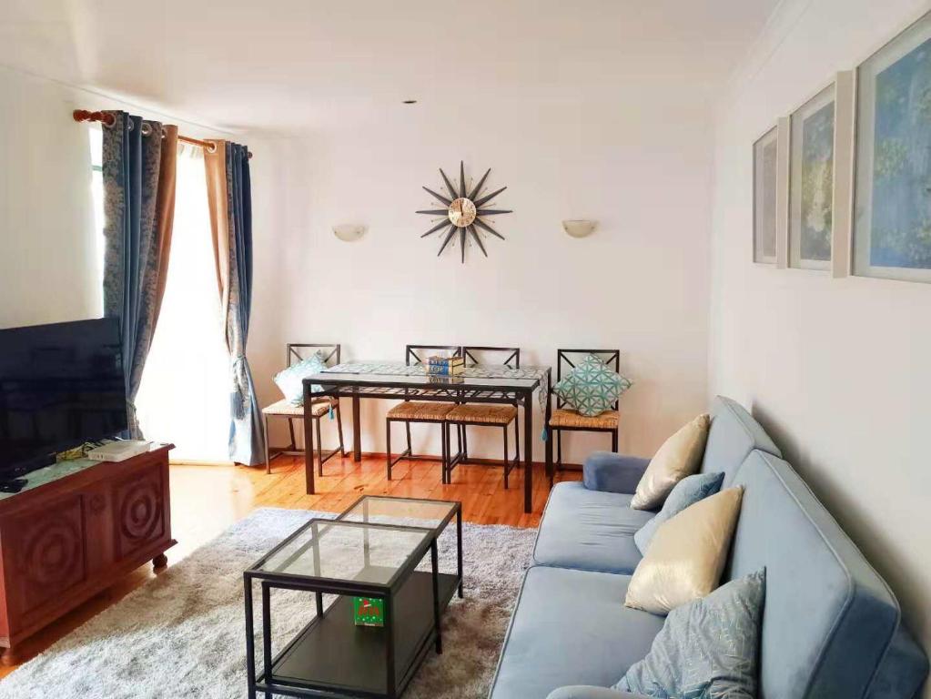 ein Wohnzimmer mit einem blauen Sofa und einem Tisch in der Unterkunft Lisbon Baixa 208 Apartment-Chiado in Lissabon