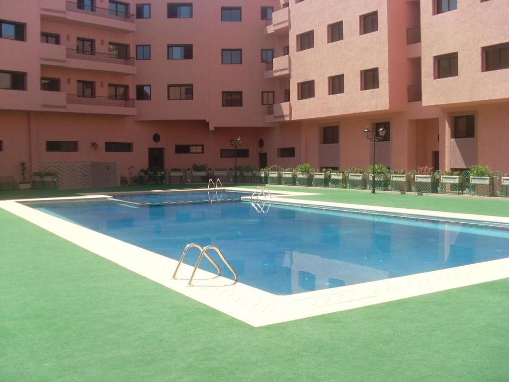 uma piscina vazia em frente a um edifício em LINA APPARTEMENT em Marrakech
