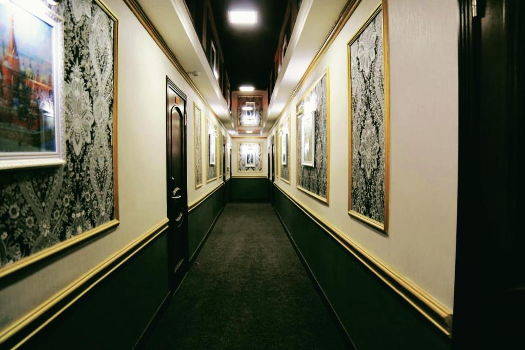 a hallway in a building with paintings on the walls at Bereke Hotel in Shchūchīnsk