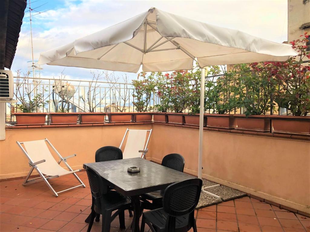 a table and chairs and an umbrella on a balcony at Case Vacanze " Il Duomo" Napoli in Naples