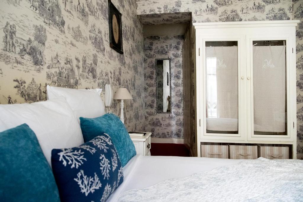 a bedroom with a bed with blue and white pillows at Hotel Villa Rivoli in Nice