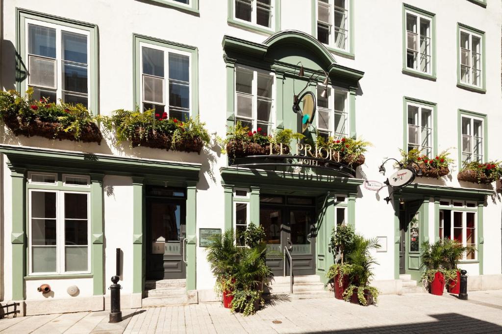 un bâtiment avec des plantes en pot sur la façade dans l'établissement Hotel le Priori, à Québec