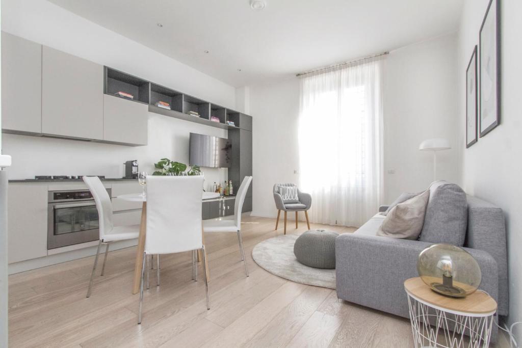 sala de estar con sofá gris y cocina en Luxury and spacious apartment (Bocconi), en Milán