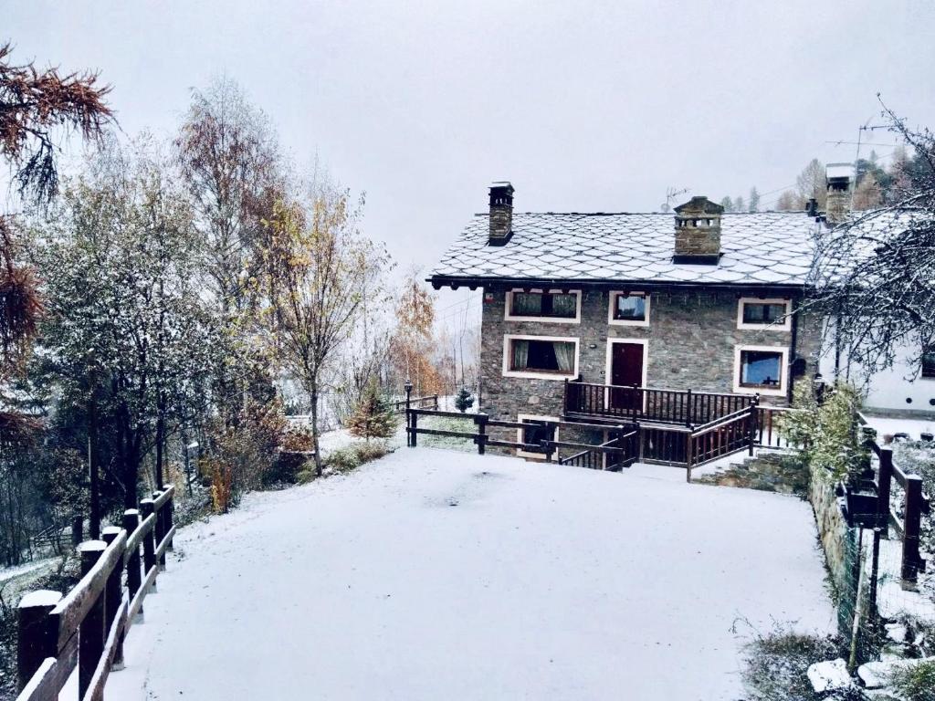 a house with a snow covered driveway in front of it at Affittacamere I Picchi in Gressan