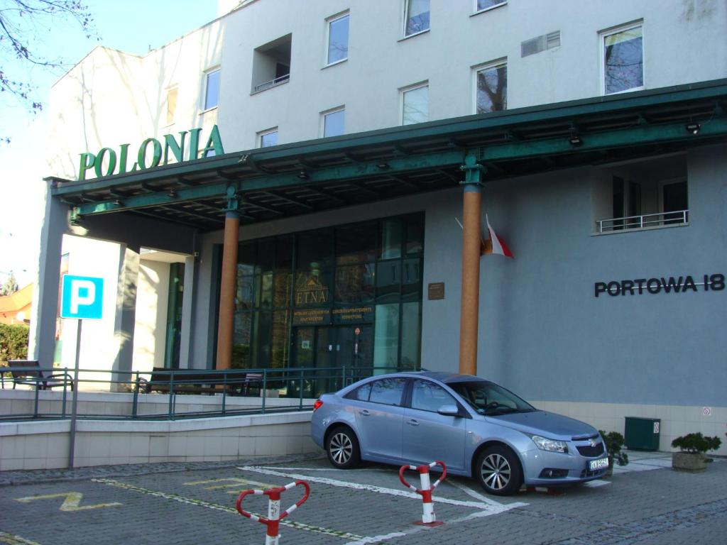 a blue car parked in front of a building at Kołobrzeg-hotel Polonia apartament 207 in Kołobrzeg