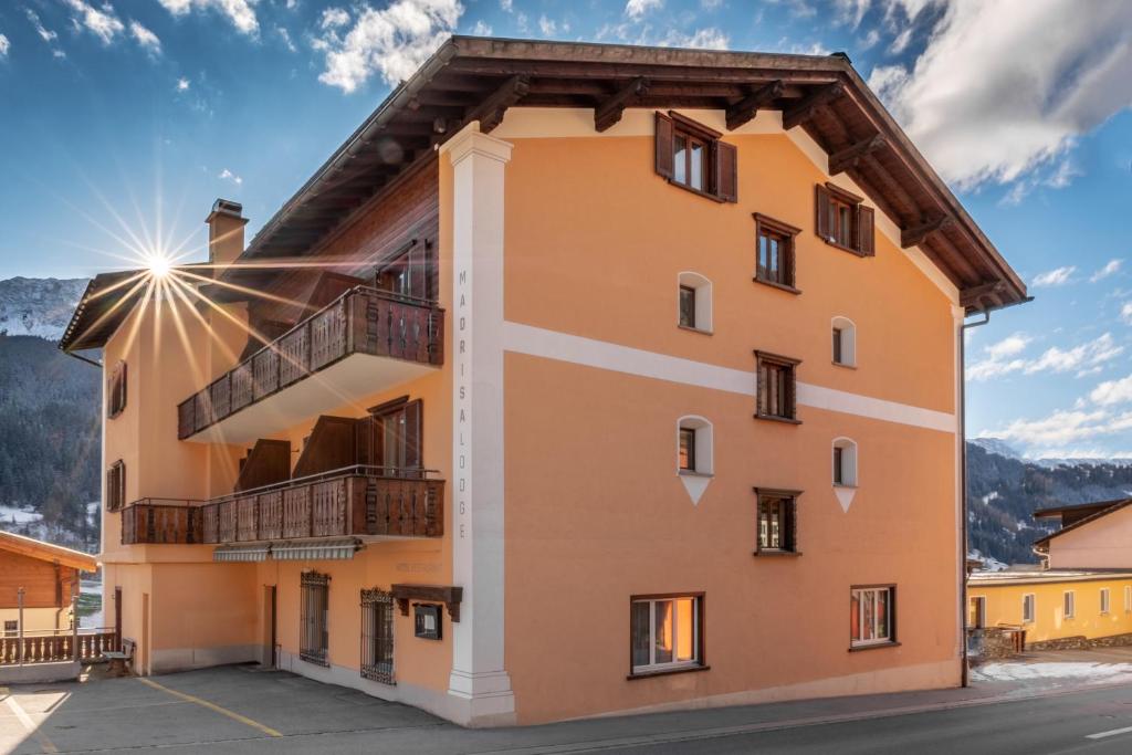 a building with a balcony on the side of it at Madrisa Lodge in Klosters