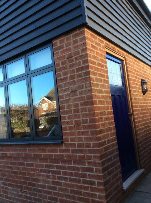 a brick building with a blue door and windows at Passengers House in Whitstable