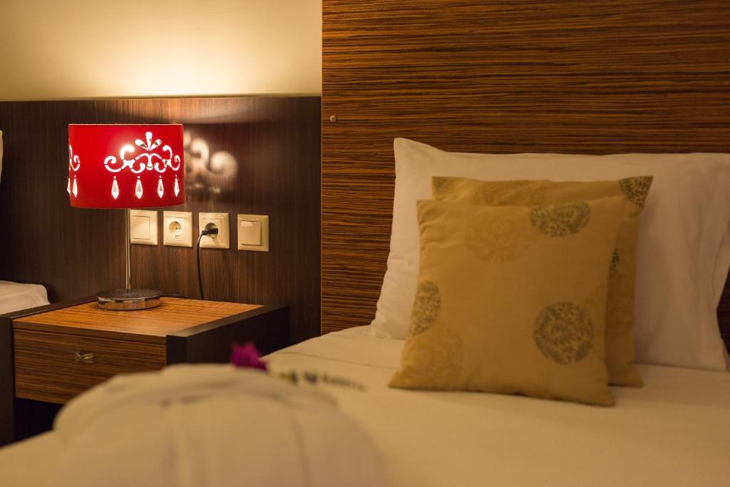 ein Schlafzimmer mit einem Bett und einer roten Lampe in der Unterkunft Sunrise Resort Hotel in Mythimna