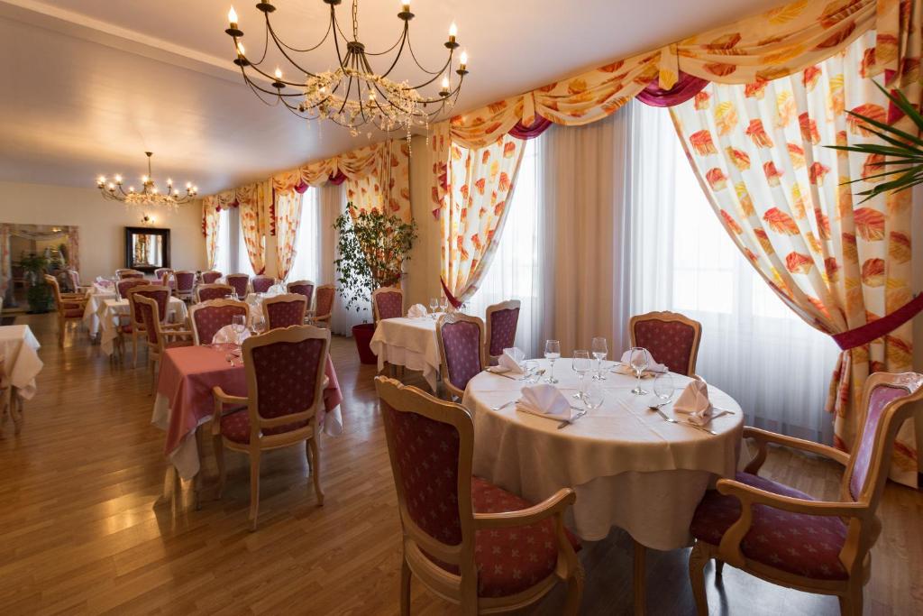 un comedor con mesas y sillas y una lámpara de araña en Hotel de Champagne, en Saint-Dizier