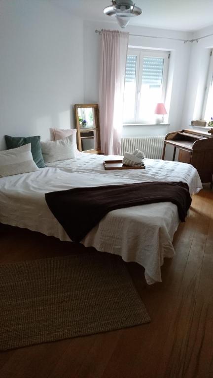 ein Schlafzimmer mit einem großen Bett mit weißer Bettwäsche in der Unterkunft Tausendschön in Alfter