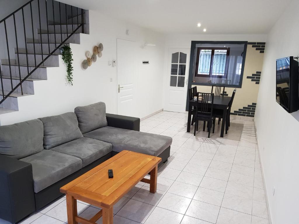 a living room with a couch and a table at Maison meublée 84 mètre carré in Ambérieu-en-Bugey