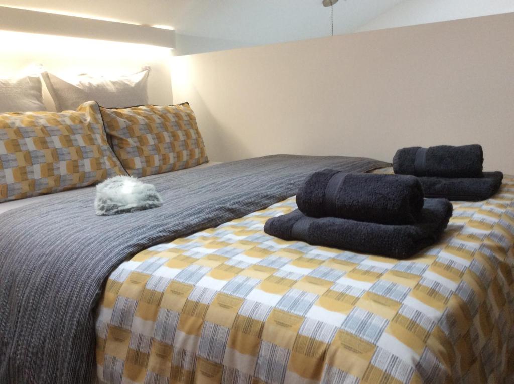 a bed with three stacks of towels on it at Passengers House in Whitstable