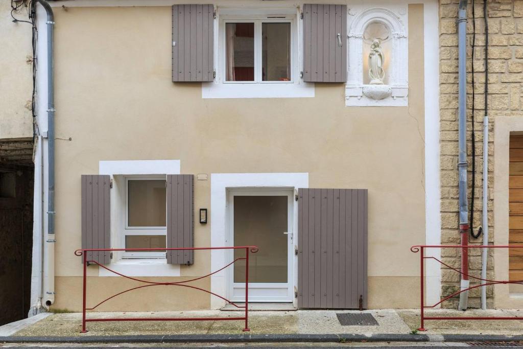 un bâtiment avec des volets gris sur son côté dans l'établissement Petite Maison du Ventoux, à Mormoiron