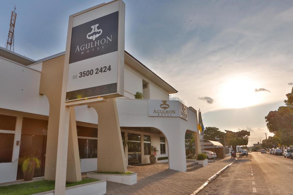 a sign for a hotel on a street at Agulhon Hotel in Primavera do Leste