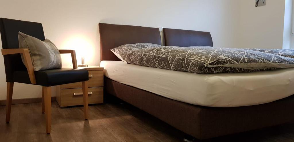 ein Schlafzimmer mit einem Bett mit einem Stuhl daneben in der Unterkunft Norderloog in Horumersiel