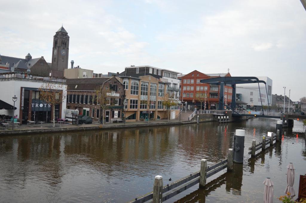 a city with a river with buildings and a bridge at Rijnzicht in Alphen aan den Rijn