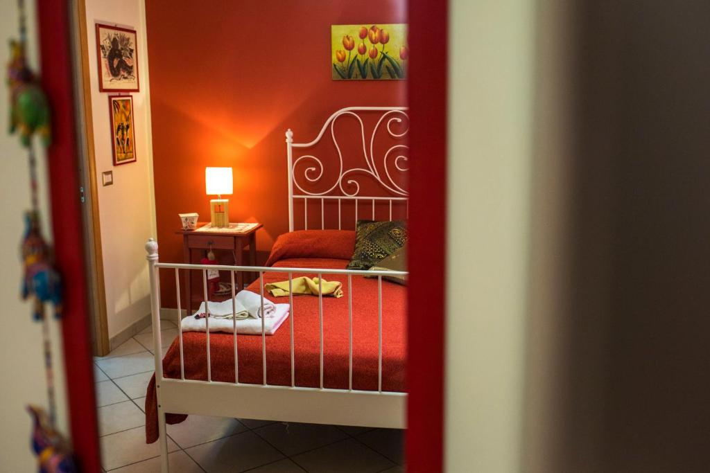 um quarto com uma cama e uma parede vermelha em B&B Miroca em SantʼAlessio Siculo