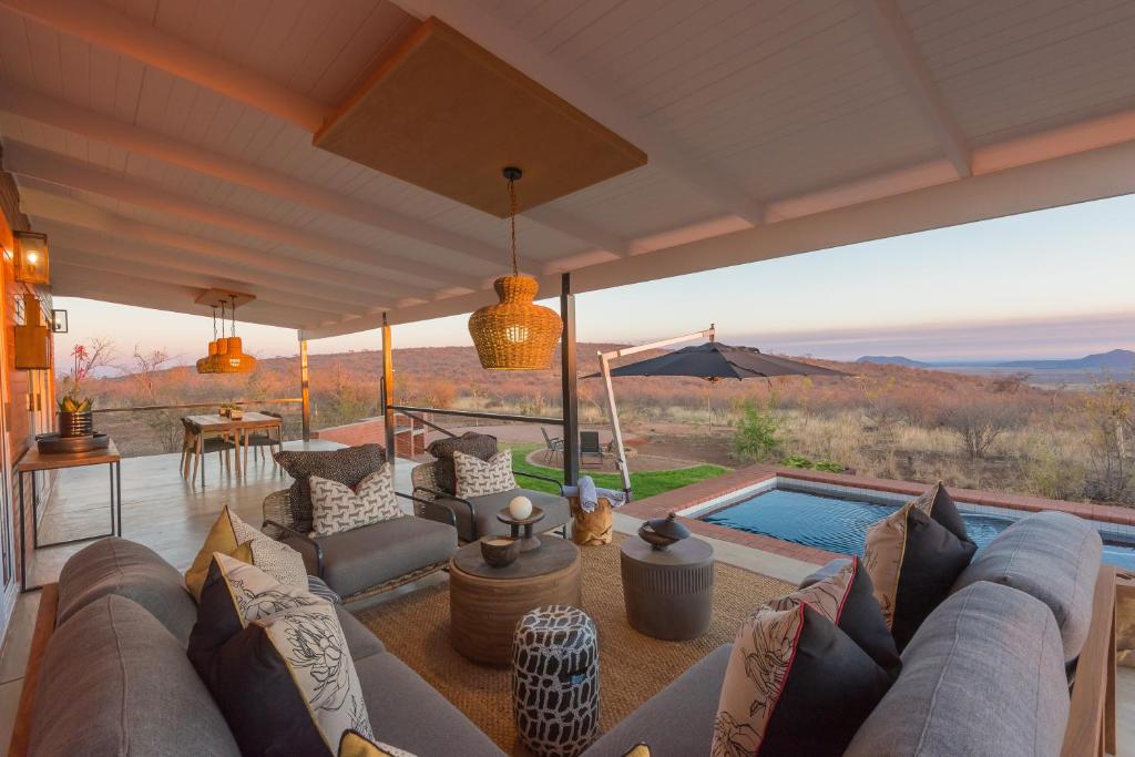 a living room with a couch and a swimming pool at Rockfig Lodge Madikwe in Madikwe Game Reserve