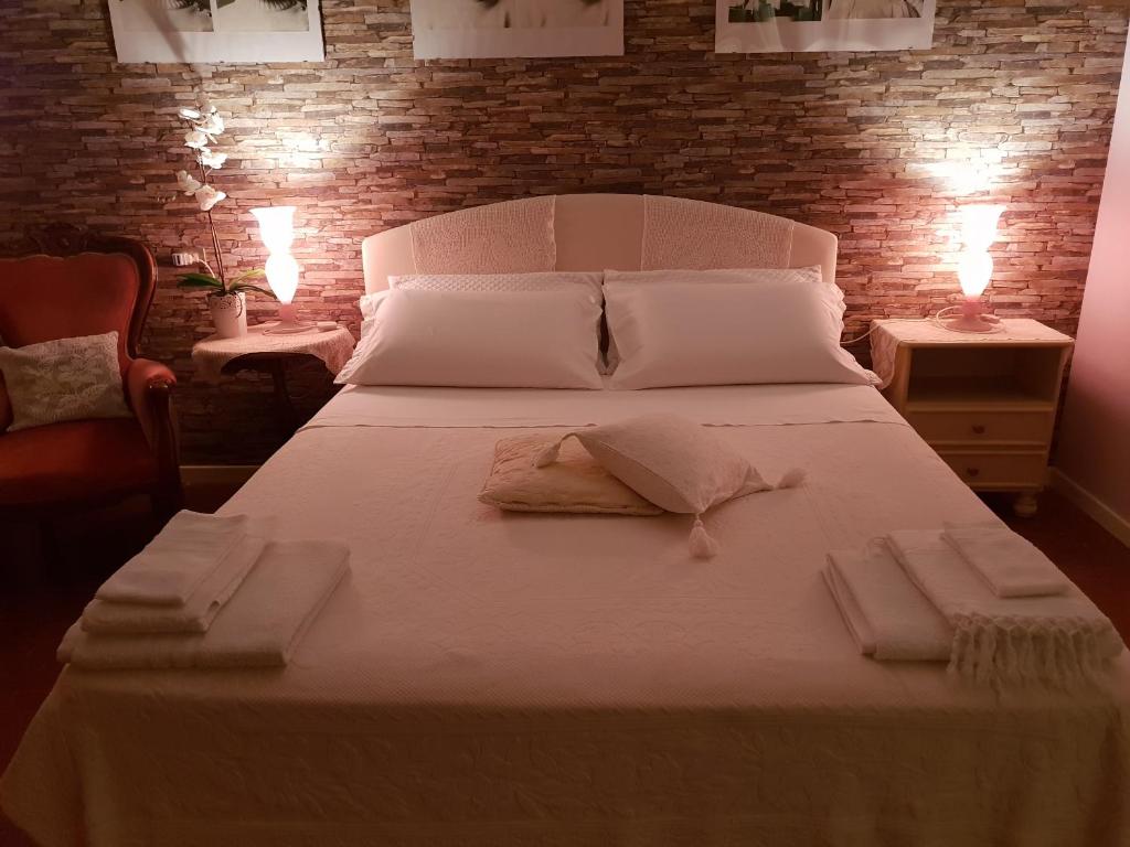 ein Schlafzimmer mit einem weißen Bett und Handtüchern darauf in der Unterkunft B&B Family Home in Soresina