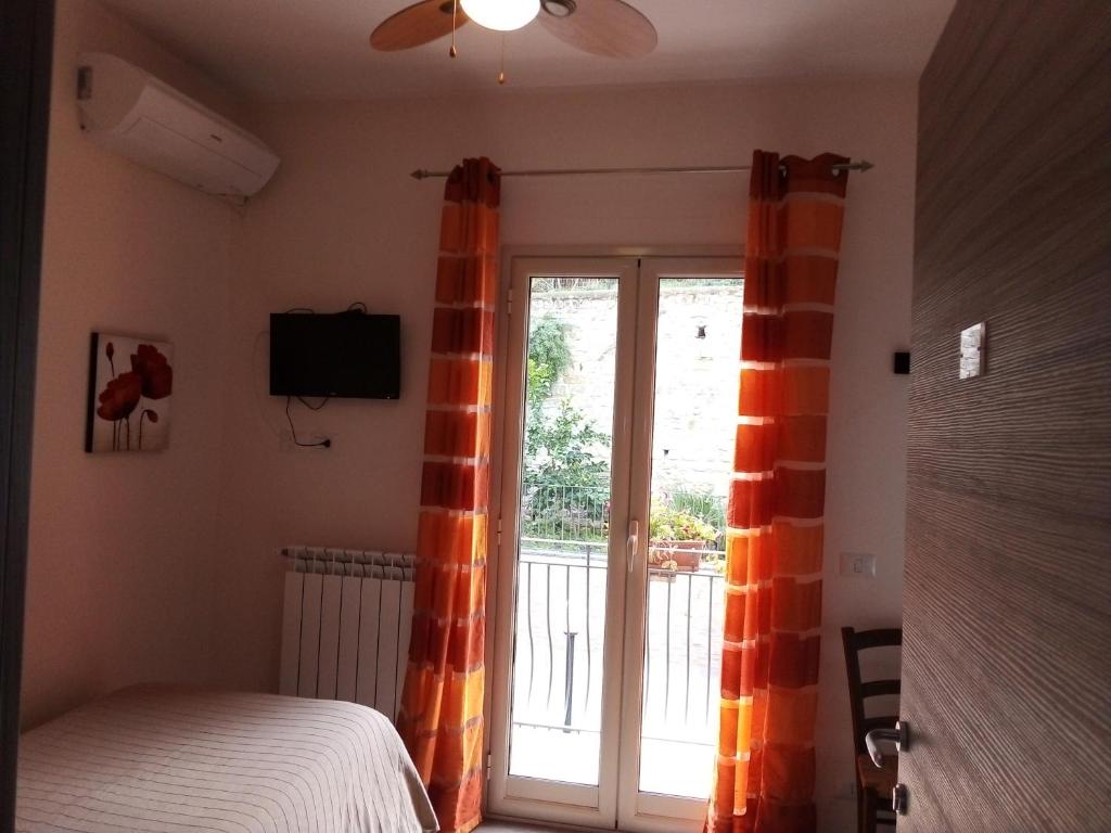 sypialnia z łóżkiem i przesuwanymi drzwiami szklanymi w obiekcie Bed & Breakfast Via Venezia w mieście Regalbuto