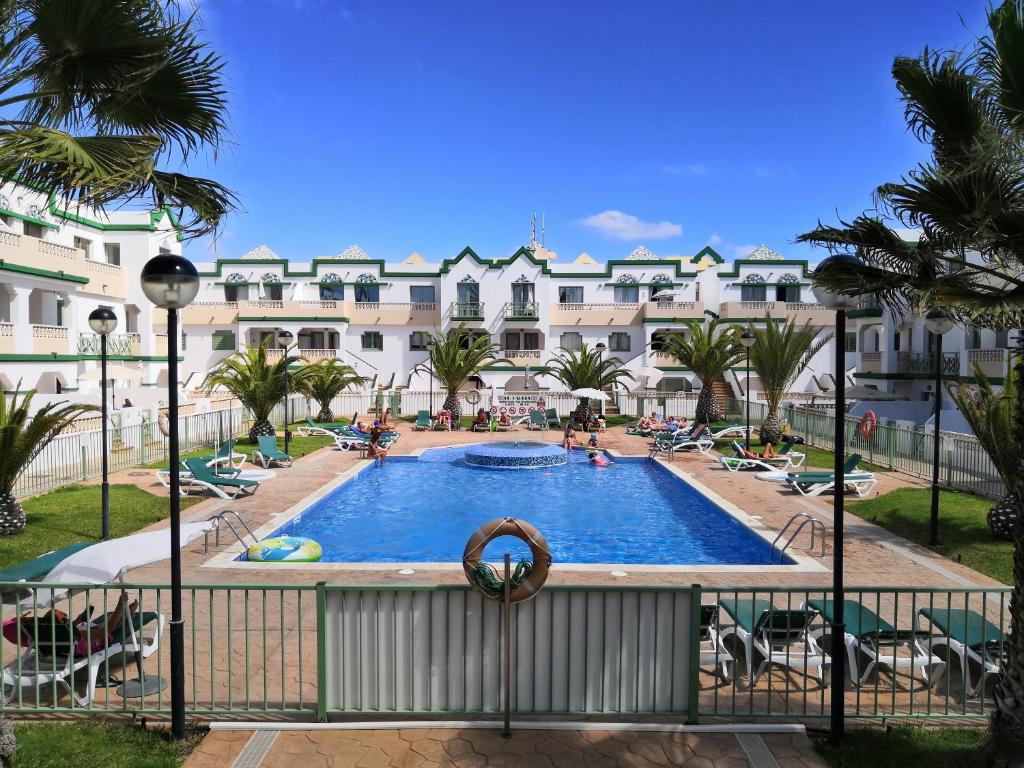 een balkon met uitzicht op een zwembad van een resort bij Estupendo Apartamento Gaudia in Caleta De Fuste