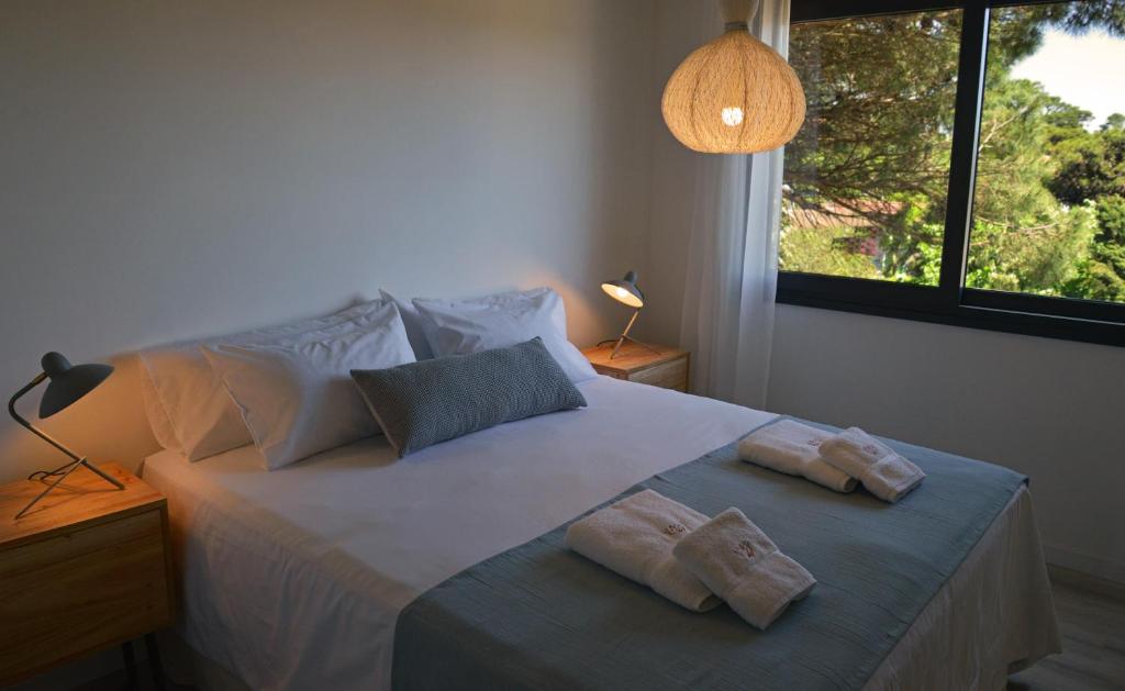 um quarto com uma cama com duas toalhas em El viejo jardin em Villa Gesell