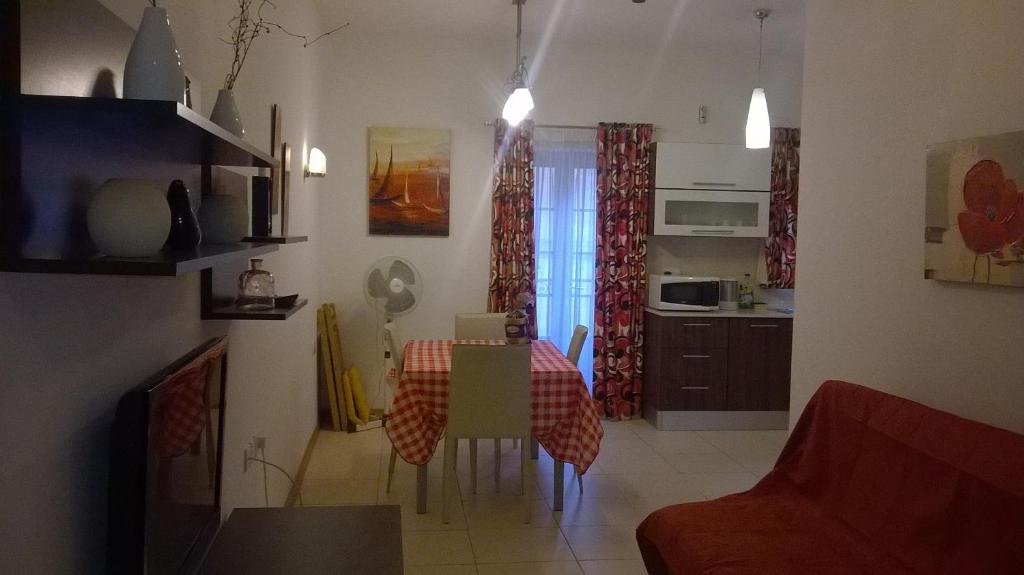 ein Wohnzimmer mit einem Tisch und einer Küche in der Unterkunft Sliema central apartment in Sliema