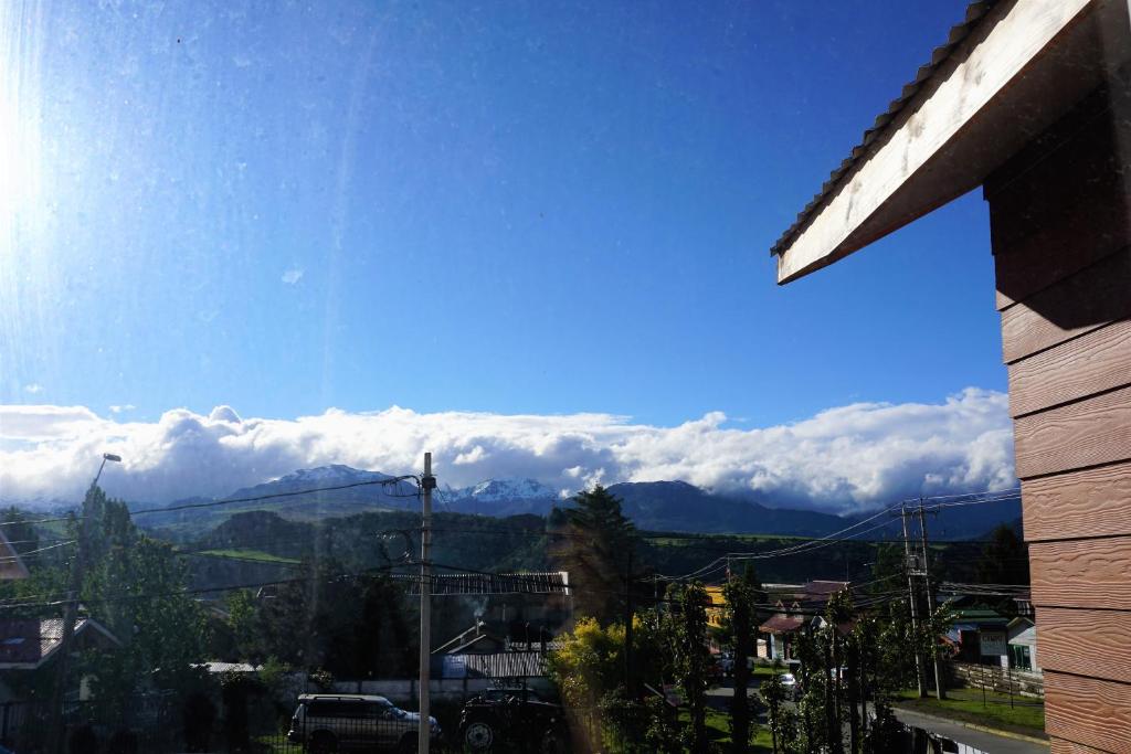 uma vista para uma serra com nuvens no céu em Hostal Casa Arrayán em Coihaique