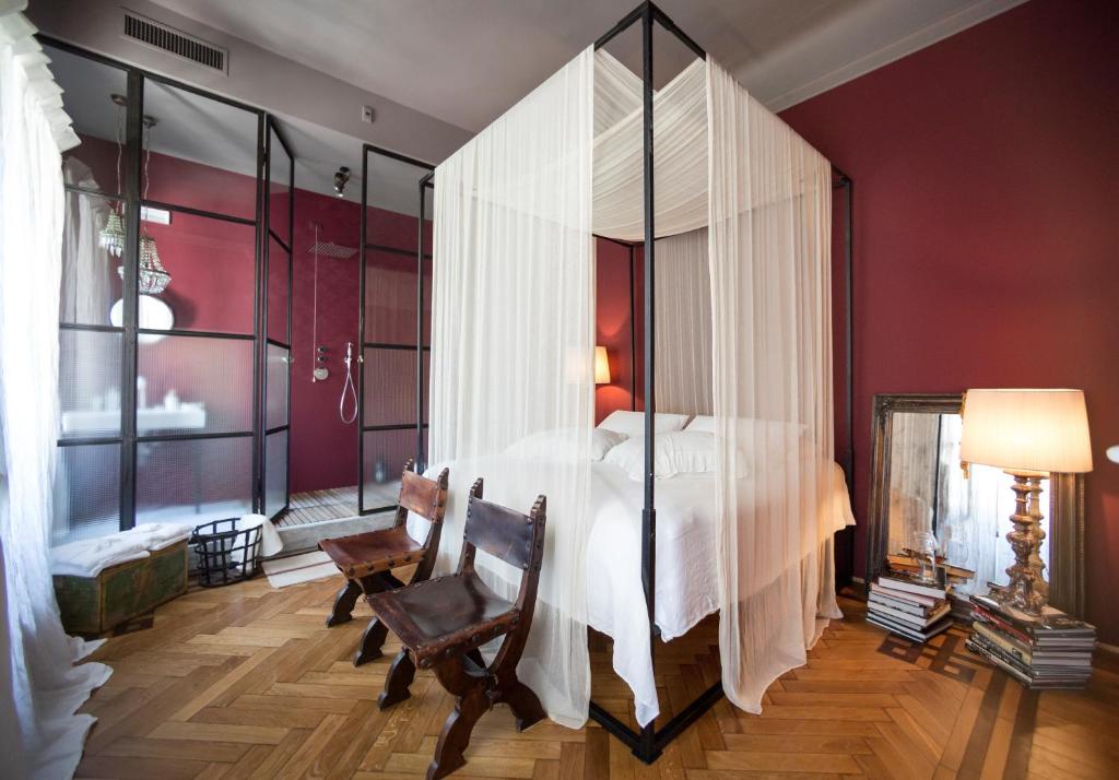 una camera da letto con un grande letto bianco con pareti in vetro di Leconvertite a Treviso