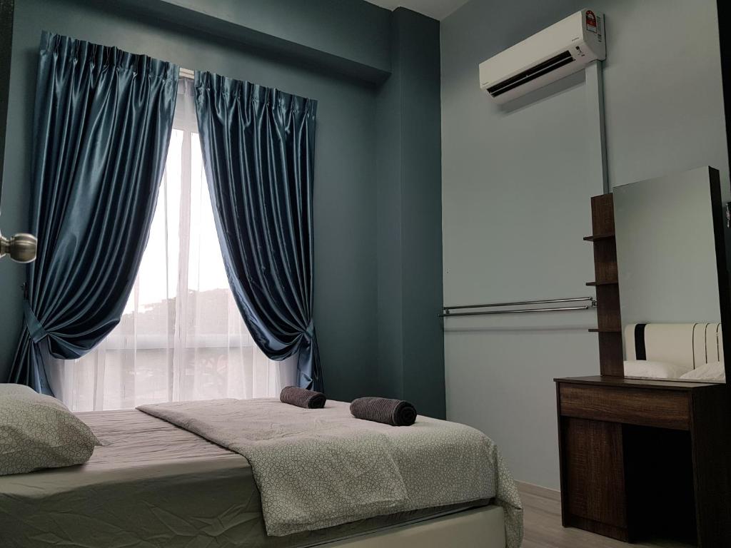 una camera da letto con un letto con pareti blu e una finestra di SS Homestay Borneo Housing SL3A a Kuching