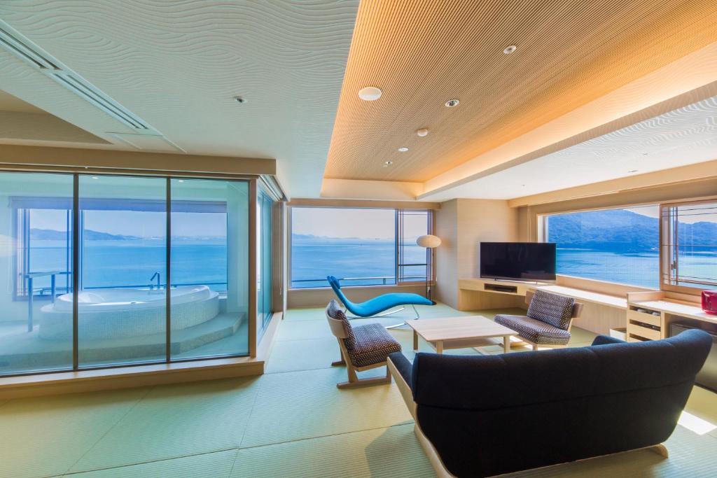 uma sala de estar com vista para o oceano em Hotel Ofutei em Fukuyama