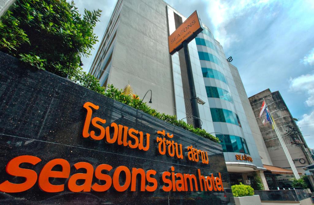 un panneau sur un mur devant un bâtiment dans l'établissement Seasons Siam Hotel, à Bangkok