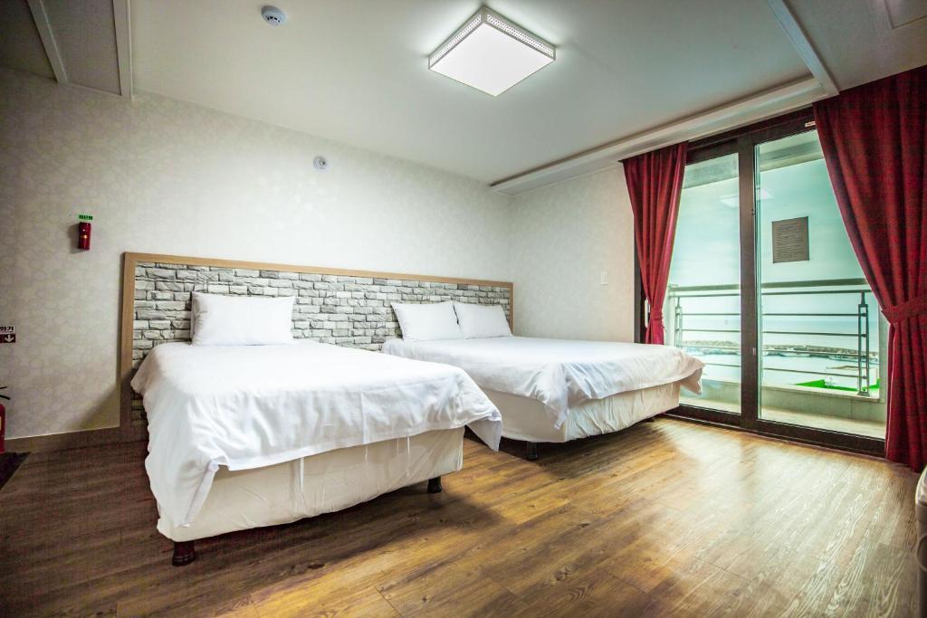 Postel nebo postele na pokoji v ubytování Jeju Moseulpo Hotel