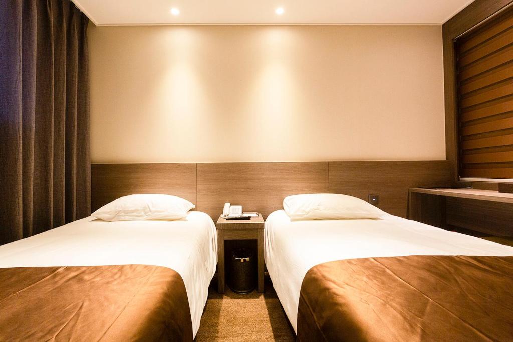 Postel nebo postele na pokoji v ubytování Grandmillions Hotel Seogwipo