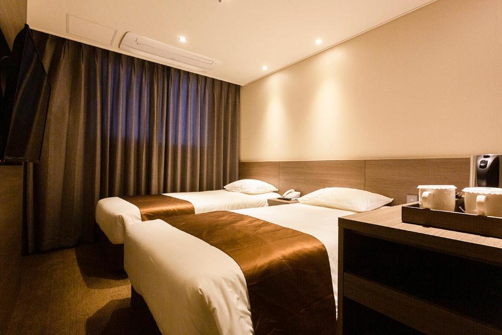 Postel nebo postele na pokoji v ubytování Grandmillions Hotel Seogwipo