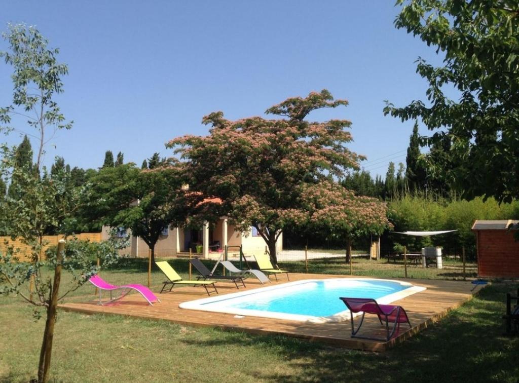 a swimming pool in a yard with chairs around it at Villa à la campagne in Camélas