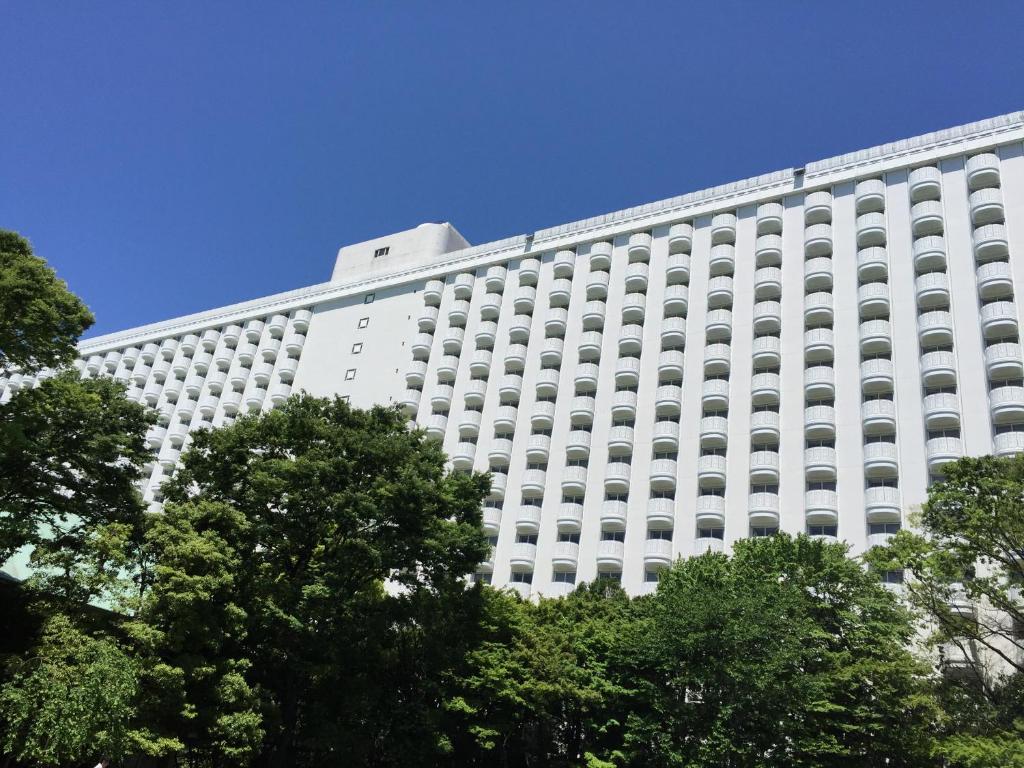 a large white building with trees in front of it at Grand Prince Hotel Shin Takanawa in Tokyo