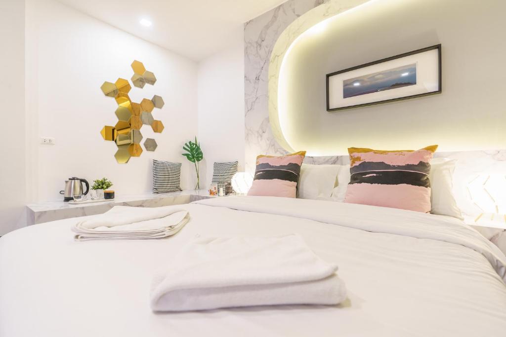 a bedroom with a white bed with towels on it at CheQinn Hostel - Sukhumvit 4 Nana Plaza in Bangkok