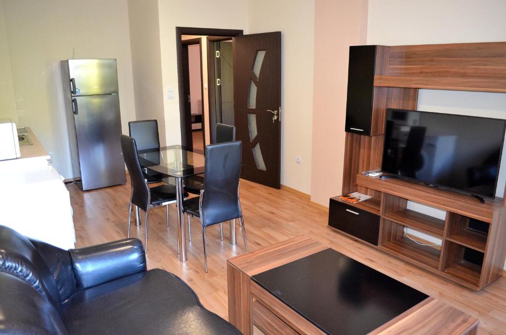 een woonkamer met een glazen tafel en een televisie bij Central Apartment 4 in Stara Zagora