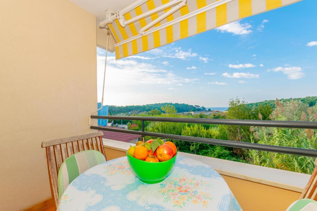 un bol de fruta sentado en una mesa en un balcón en Apartment IRENA with Bikes included, en Pula