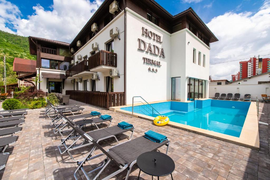 un hôtel avec une piscine en face d'un bâtiment dans l'établissement Hotel DADA Termal, à Călimăneşti