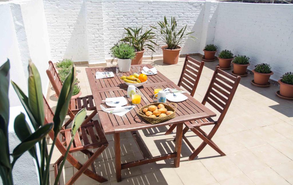 a wooden table with a bowl of fruit on a patio at Cool Loft Malvarrosa Beach in Valencia